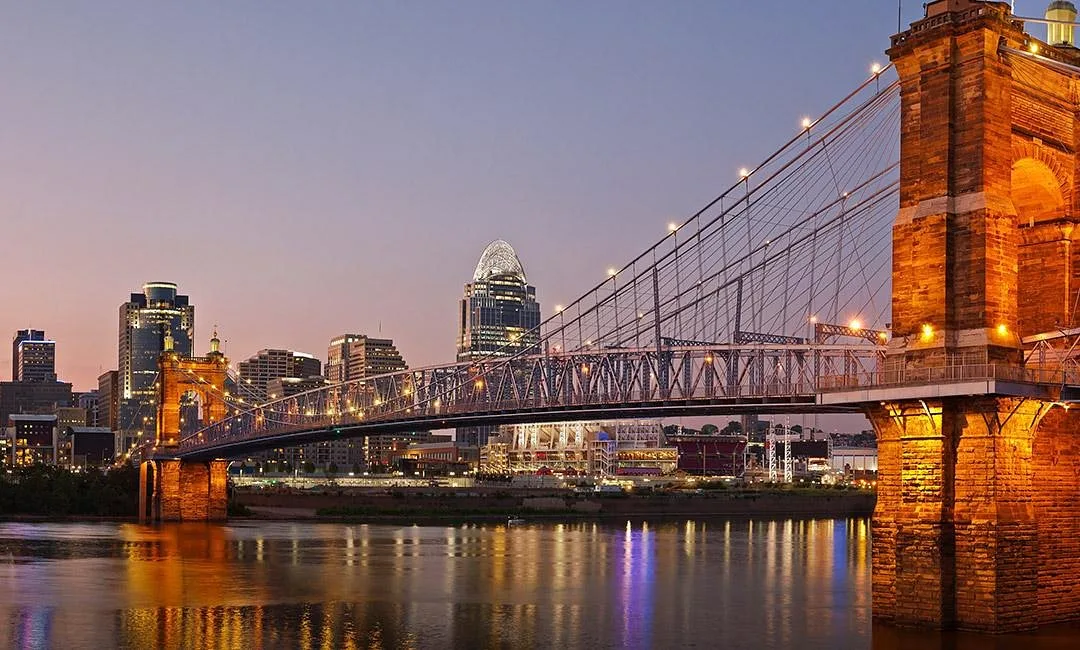 downtown Cincinnati skyline and the Roebling Bridge at dusk